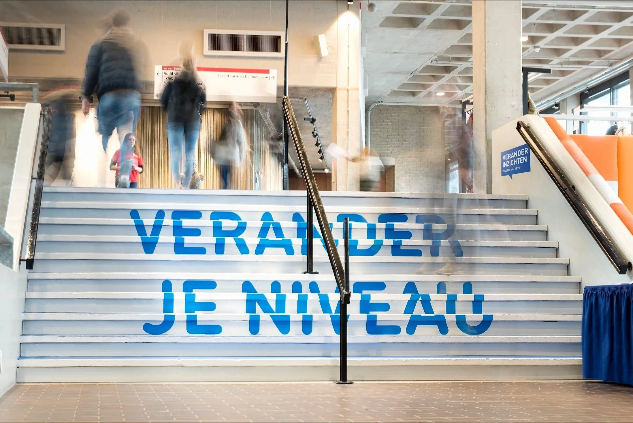 Trap in het VU-gebouw met de tekst "Verander je niveau" op de treden